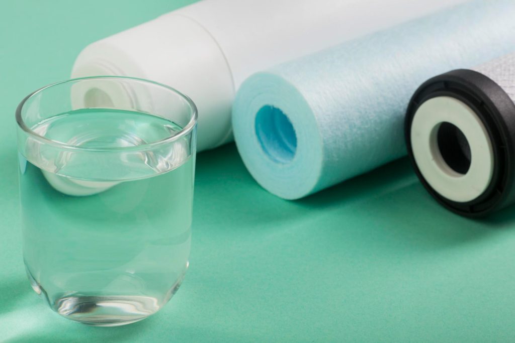 Vaso de agua al lado de tres rollos