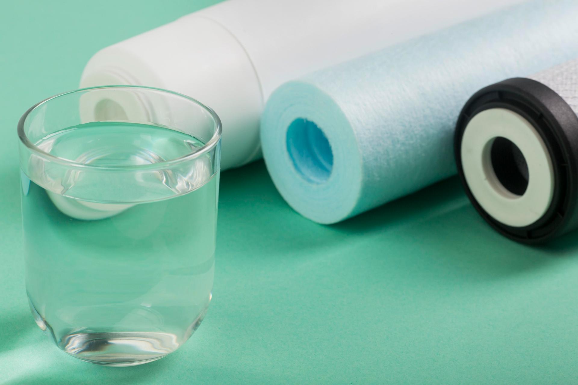 Vaso de agua al lado de tres rollos